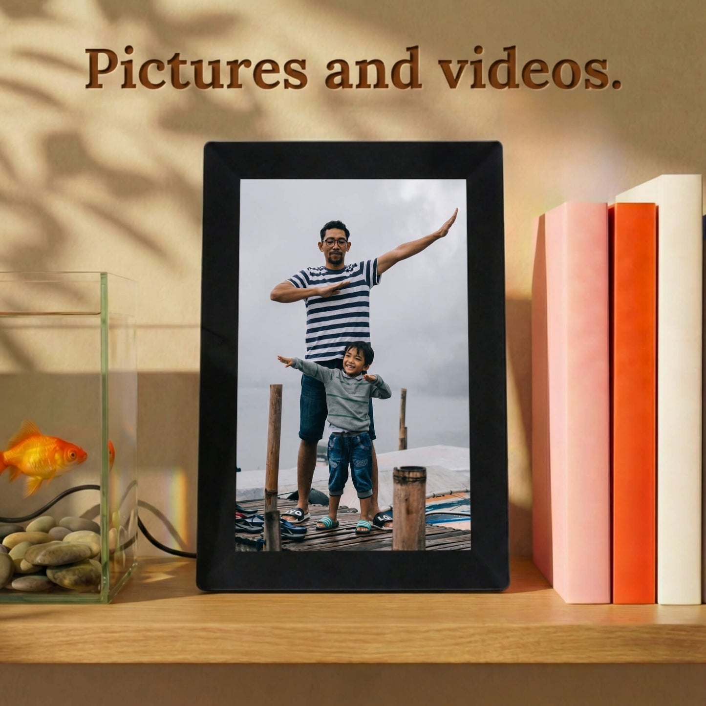 A vertically standing 10-inch black Family Frame digital memory display resting on a warm wooden shelf next to colorful books. Equipped with advanced processing, this premium digital picture frame flawlessly handles both high-definition photo and video playback to capture full, dynamic memories. The robust photo sharing frame allows distant relatives to securely send video messages directly to any living space.
