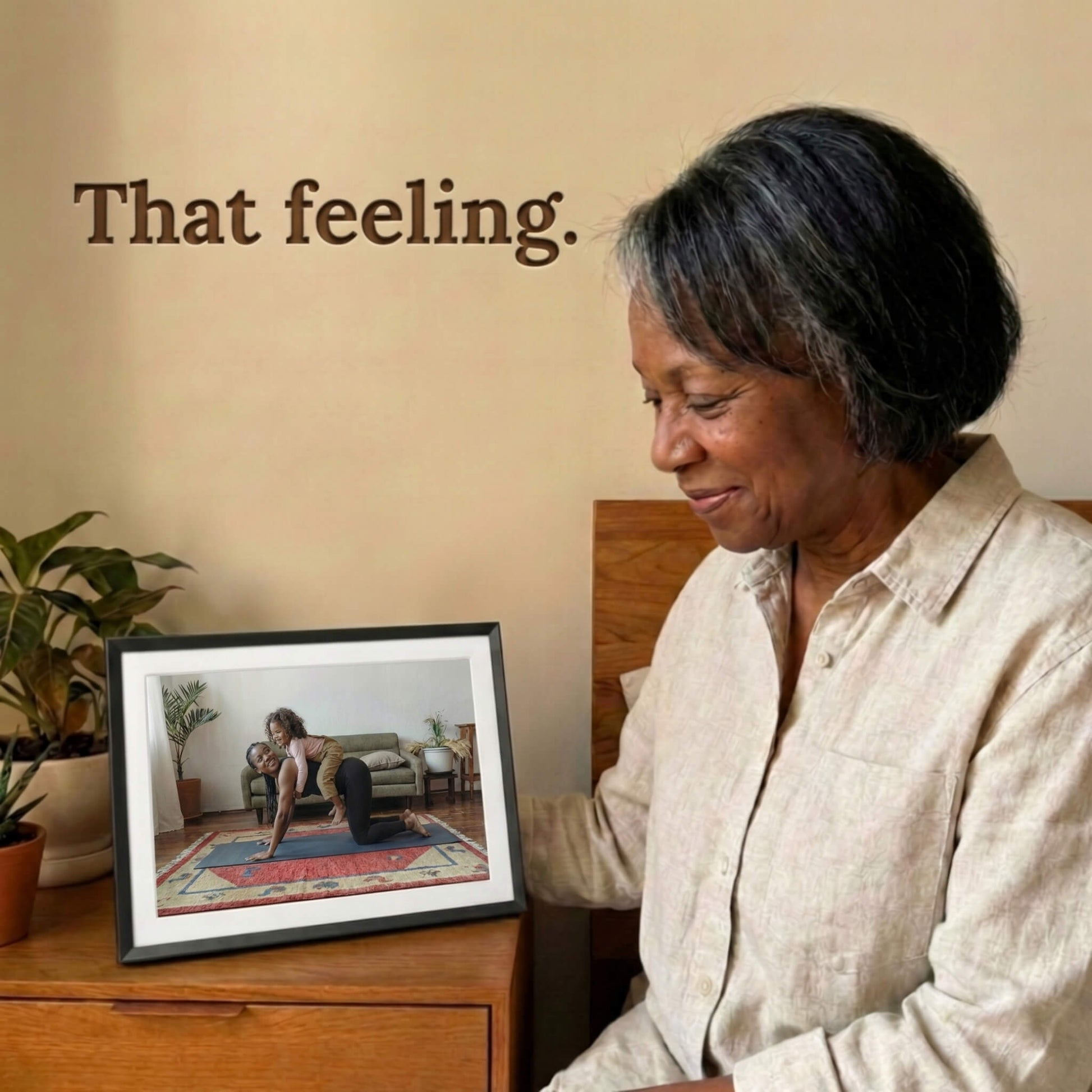 A 10-inch classic black Family Frame WiFi photo frame with a white mat positioned on a wooden nightstand beside a warm lamp. Engineered specifically as a heartwarming long-distance family gift, this smart picture frame instantly receives new photos from loved ones living far away. It functions as a powerful digital memory display to consistently spark joy and combat loneliness through shared experiences.
