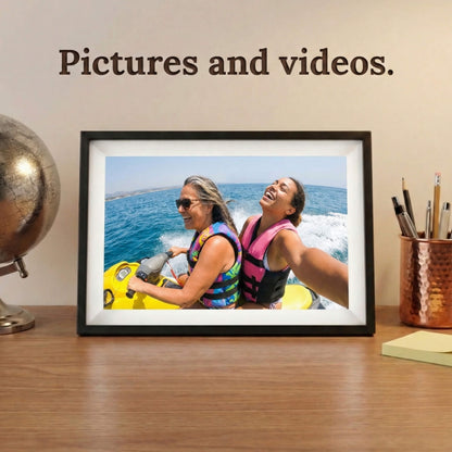 A 10-inch cordless classic black Family Frame digital memory display with an elegant white mat sitting comfortably on a wooden desk next to a classic globe. Equipped with advanced processing, this premium cordless digital picture frame seamlessly handles both high-definition photo and video playback to capture full memories. The robust photo sharing frame allows distant relatives to securely send video messages directly to any room in the house.
