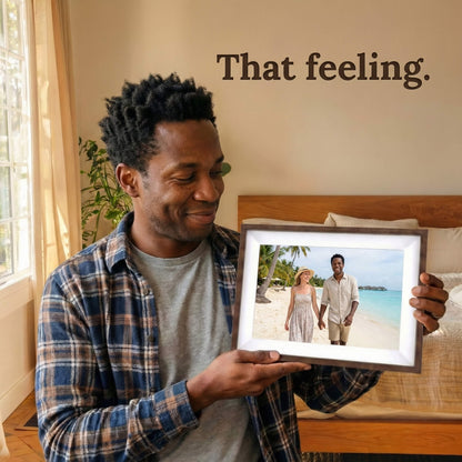 A 10-inch cordless mocha wood Family Frame WiFi photo frame with a white mat being held by a user in a warmly lit, comfortable living space. Engineered specifically as a heartwarming long-distance family gift, this wire-free smart picture frame instantly receives new photos from loved ones living far away. It functions as a powerful digital memory display to consistently spark joy and combat loneliness through shared experiences without the constraint of power cords.
