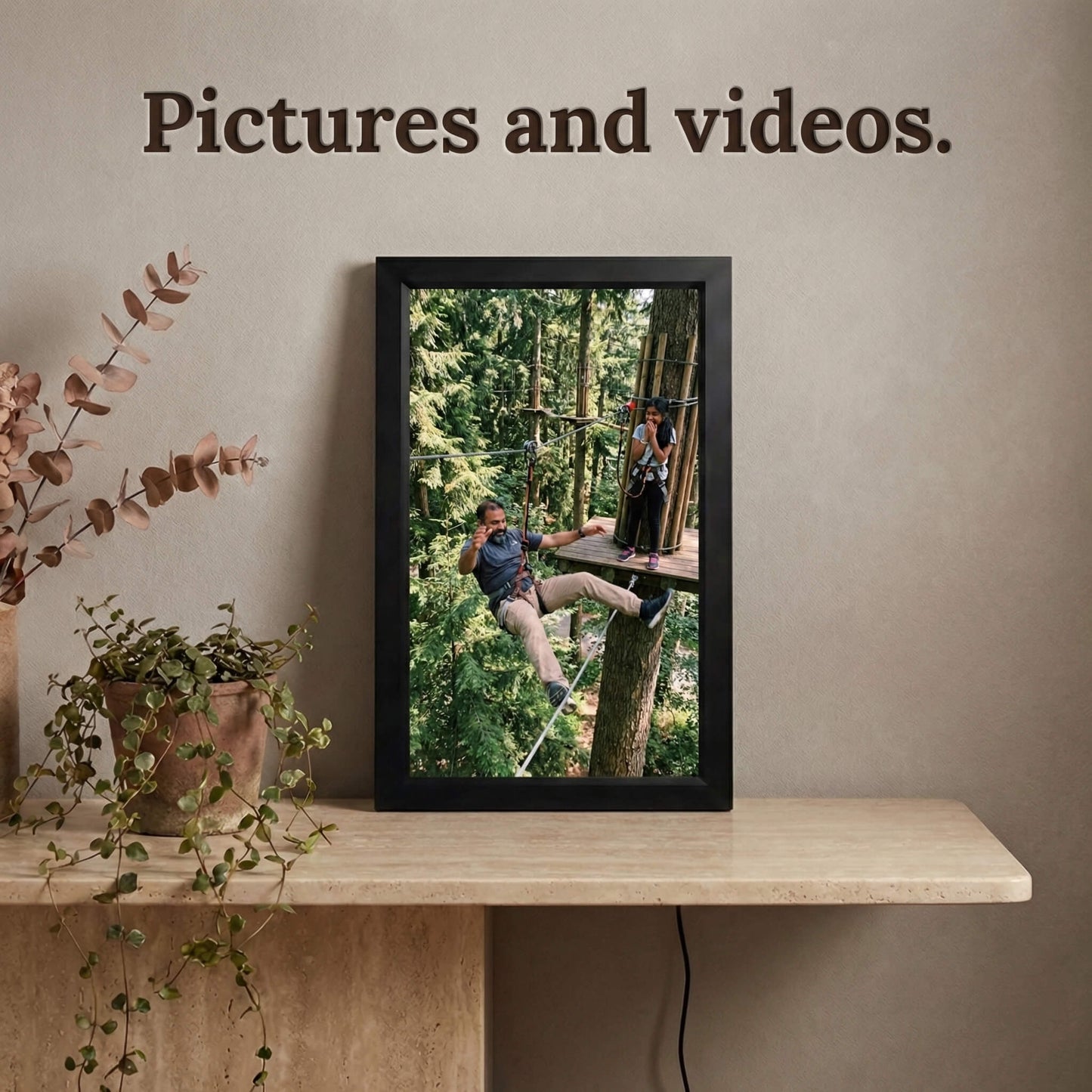 A vertically standing 16-inch black Family Frame digital memory display resting on a floating light wood shelf. Equipped with advanced processing, this premium digital picture frame flawlessly handles both high-definition photo and video playback to capture full, dynamic memories. The robust photo sharing frame allows distant relatives to securely send video messages directly to the living room display.
