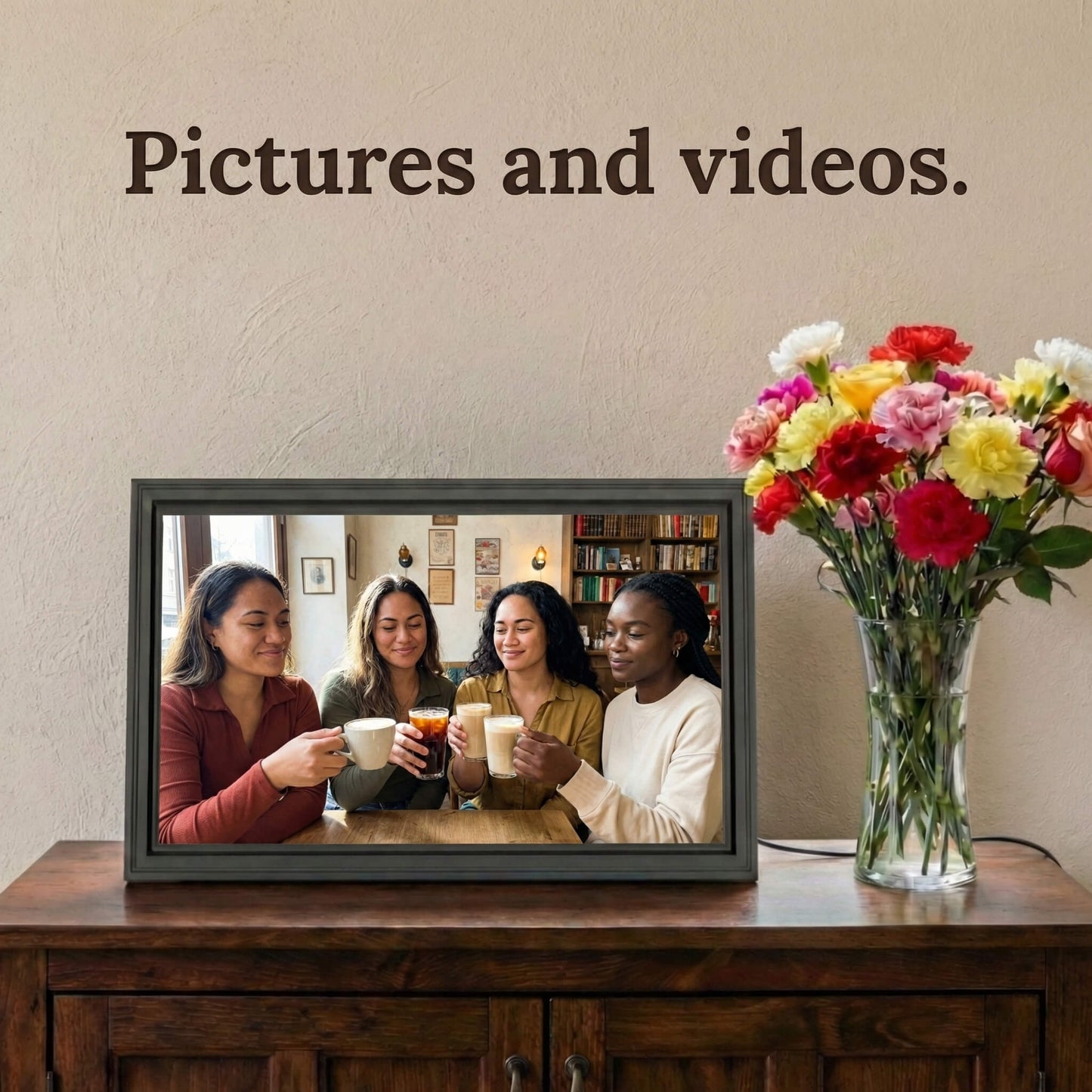 A 16-inch studio black Family Frame digital memory display resting on a rich wooden credenza beside a vibrant floral arrangement. Capable of bringing dynamic moments to life, this advanced digital picture frame supports flawless high-definition photo and video playback. As a premium photo sharing frame, it allows unlimited users to securely transmit vibrant video memories over a wireless connection.
