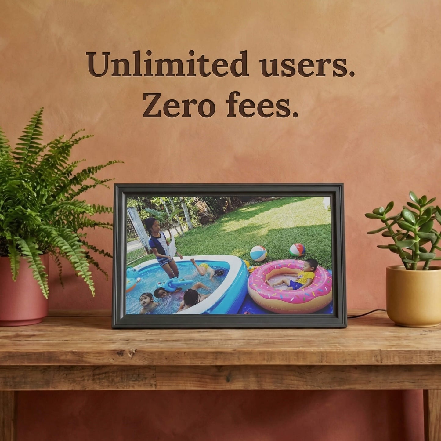 A 16-inch studio black Family Frame digital picture frame sitting on a rustic wooden table illuminated by warm natural light. Built to unite large families, this smart picture frame securely accepts instant uploads from an unlimited number of invited users globally. Operating entirely as a no subscription fee digital frame, it represents the most reliable way to maintain long-distance family connections over time.
